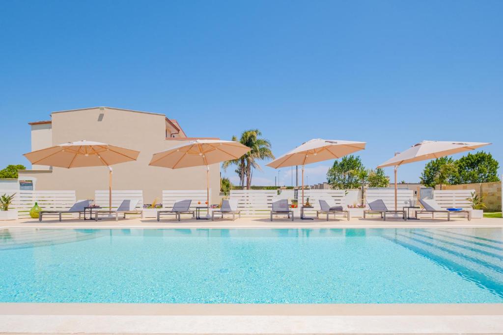 una piscina con sedie e ombrelloni di Villa Malea Luxury - Otranto a Giuggianello