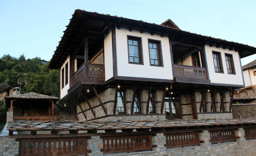 a house with a balcony on top of a building at Delchevata Kushta V Leshten in Leshten