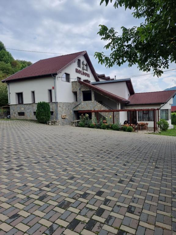 a building with a cobblestone street in front of it at Pensiunea Moldova in Piatra Neamţ