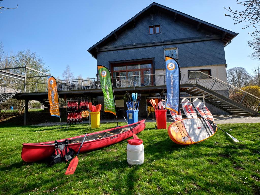 un groupe de canoës sur l'herbe devant une maison dans l'établissement Youth Hostel Lultzhausen, à Lultzhausen