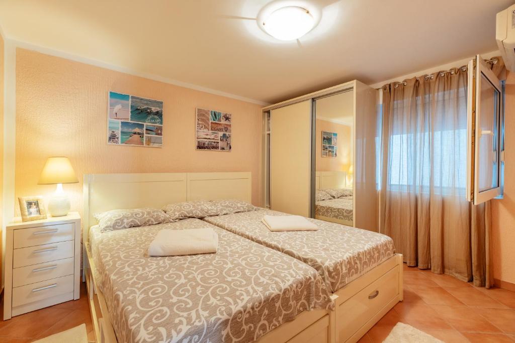 a bedroom with a large bed and a mirror at lux porodicni apartman Ciric in Herceg-Novi