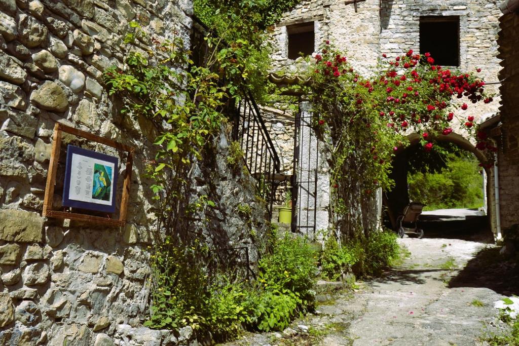a stone building with a picture on a wall with flowers at Gîte &#39;An Kay Ou&#39; - Le Grand Barry in Pontaix