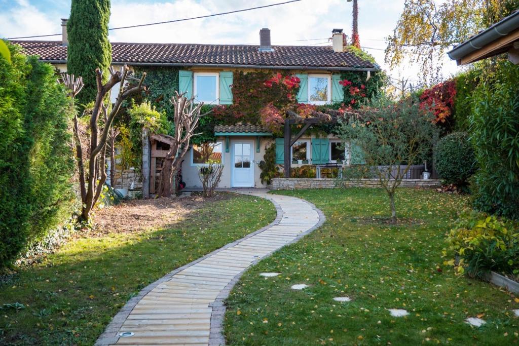 a house with a walkway in front of a yard at La Petite Maison in Charly