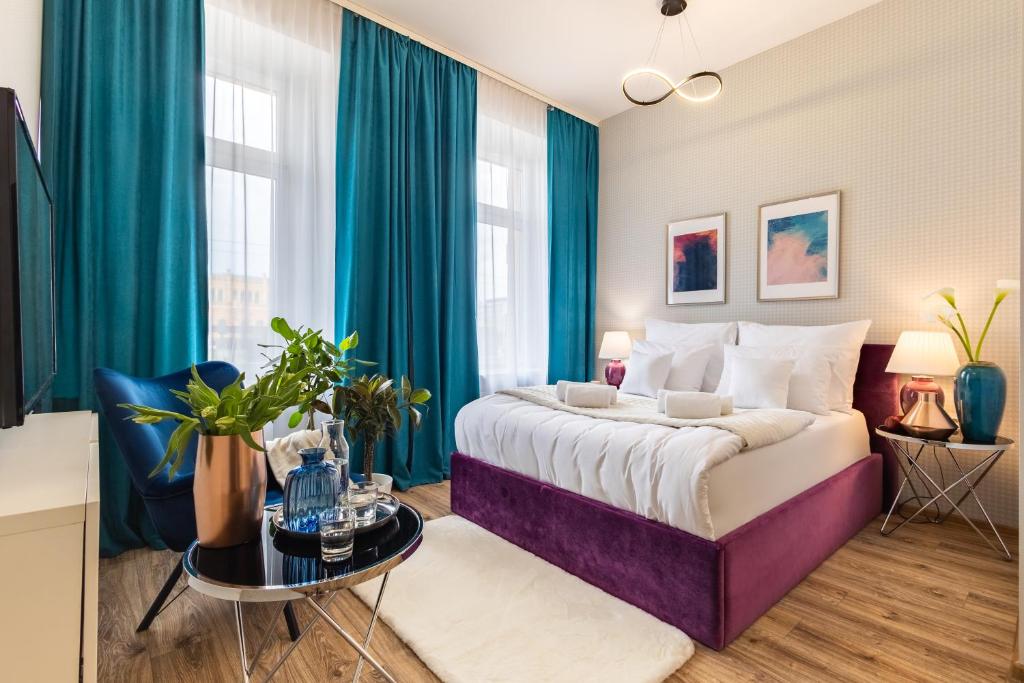 a bedroom with a large bed with blue curtains at Hotel Sofia by The Railway Station Wroclaw in Wrocław