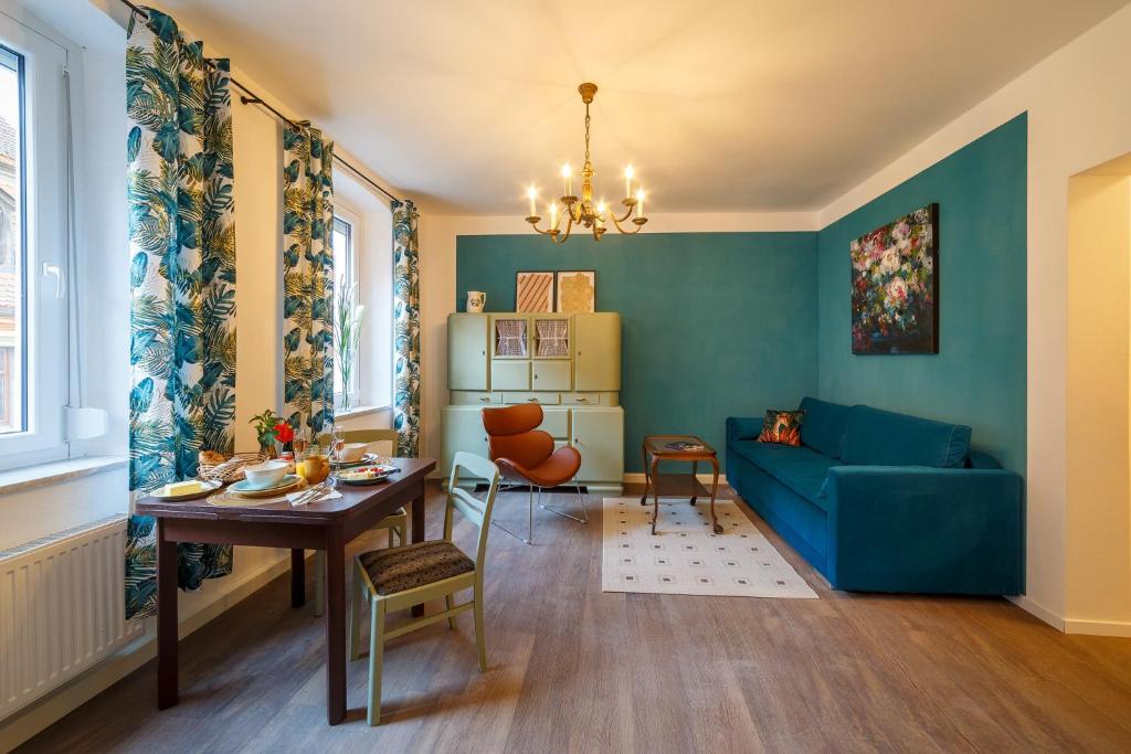 ein Wohnzimmer mit einem blauen Sofa und einem Tisch in der Unterkunft Alte Färberei - Wohnen in der Altstadt in Kulmbach