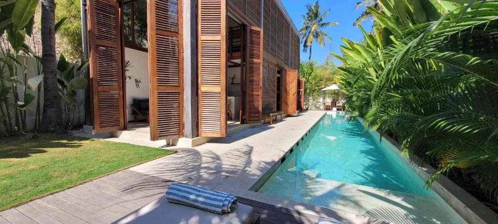 a swimming pool in the backyard of a house at Villa Merbau - Luxury Tropical Private Pool Villa in Gili Islands