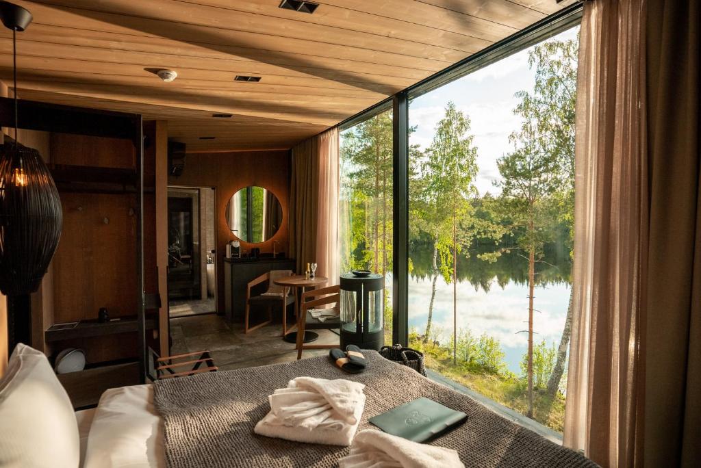 a bedroom with a bed and a large window at Kuru Resort in Rantasalmi