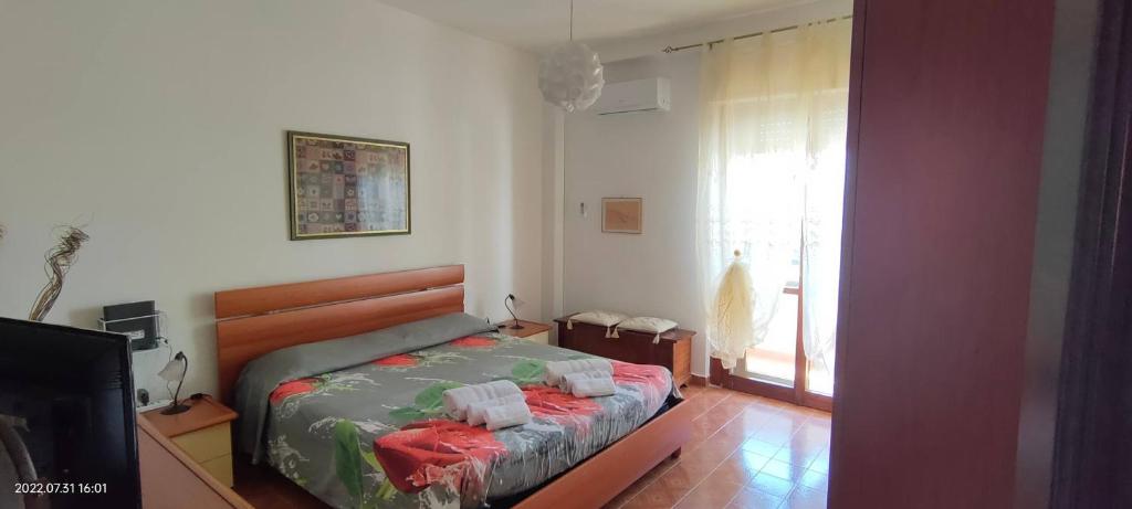a bedroom with a bed and a tv and a window at Room in Apartment - La Palma King Room With Balcony in Cagliari