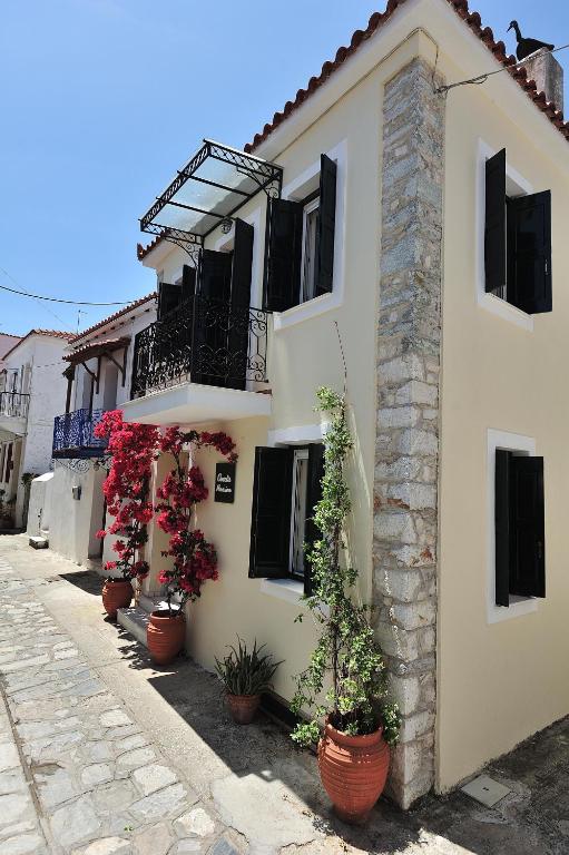 a building with potted plants on the side of it at Orestis Mansion Skiathos in Skiathos