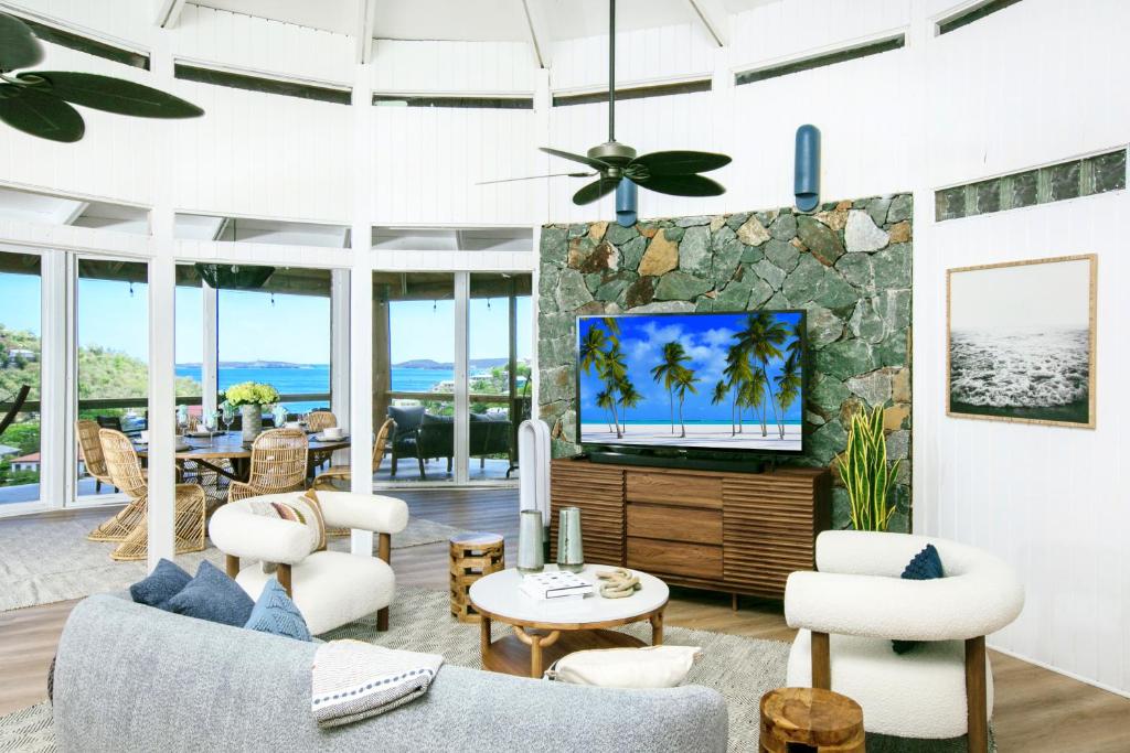 sala de estar con muebles blancos y TV en Architect-Designed Villa en Enighed