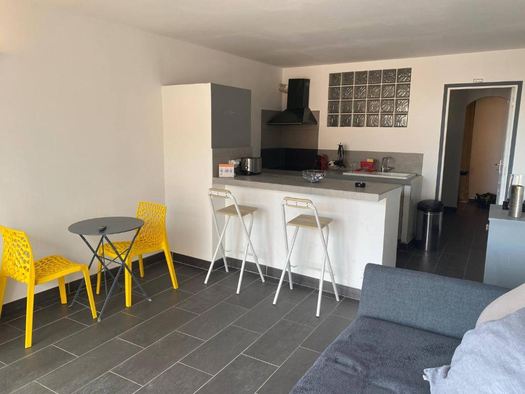 a kitchen with a counter and chairs and a table at Jolie T2 bord de mer corse du sud in Conca