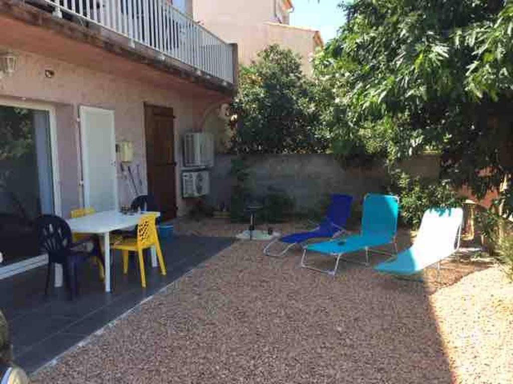 a patio with chairs and a table and a table and chairs at Jolie T2 bord de mer corse du sud in Conca