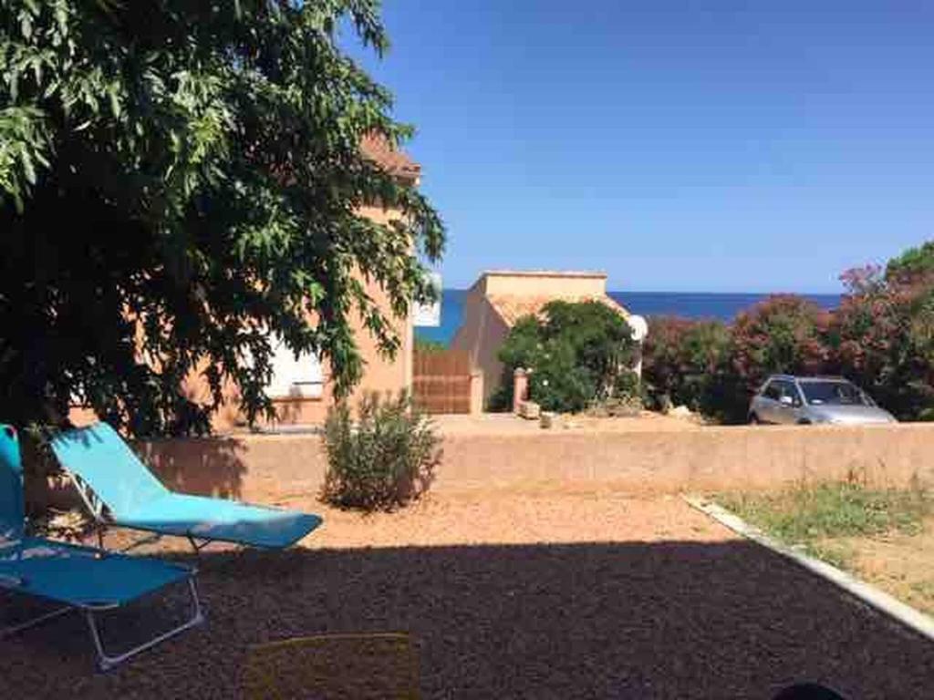 a couple of blue chairs sitting in a yard at Jolie T2 bord de mer corse du sud in Conca