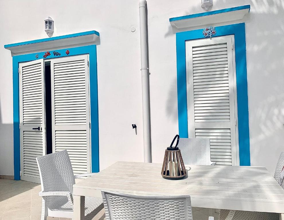 una sala da pranzo con porte blu e bianche, tavolo e sedie di Ponza Luxury a Ponza