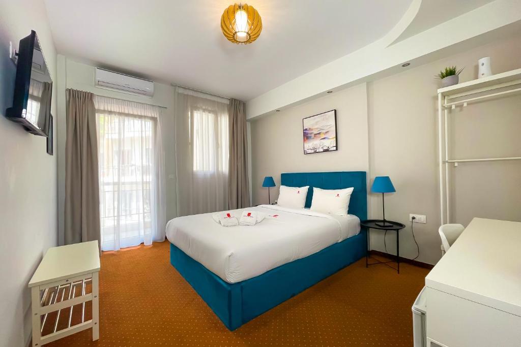 a bedroom with a large bed with a blue headboard at City Plaza Apartments & Rooms in Thessaloniki