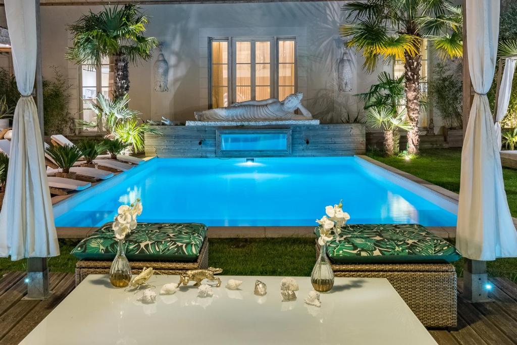 a pool in a backyard with two chairs and a table at Buddha Beach Thoiry in Thoiry