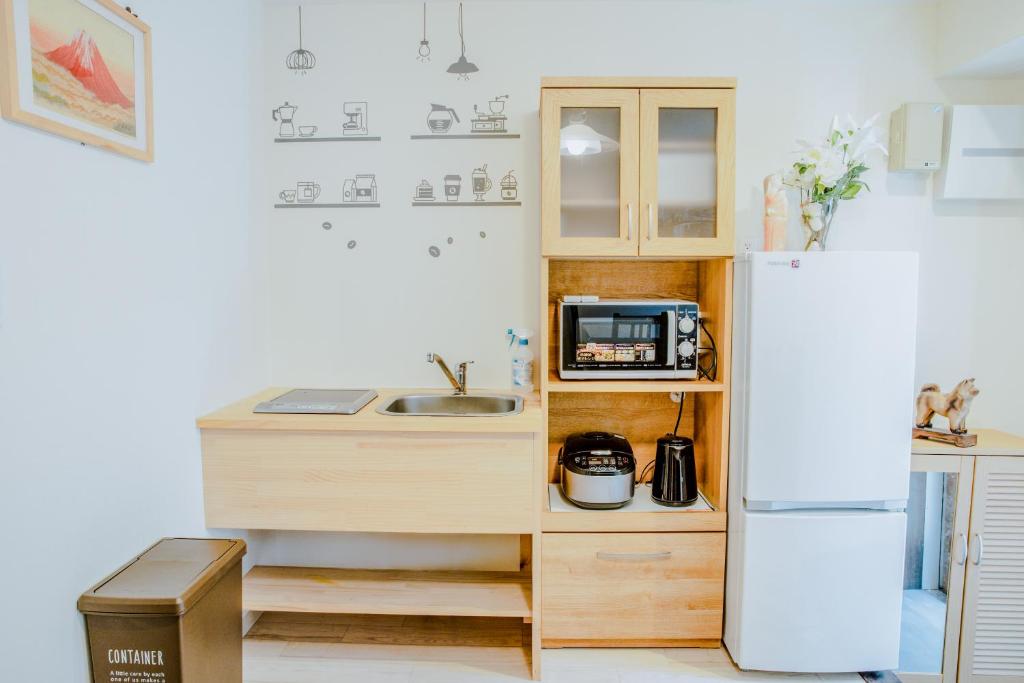 a small kitchen with a sink and a refrigerator at 桜の宿 in Osaka