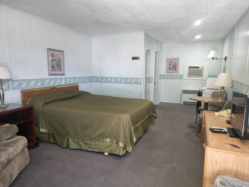a bedroom with a bed and a desk and a television at White Valley Motel in Saint Charles