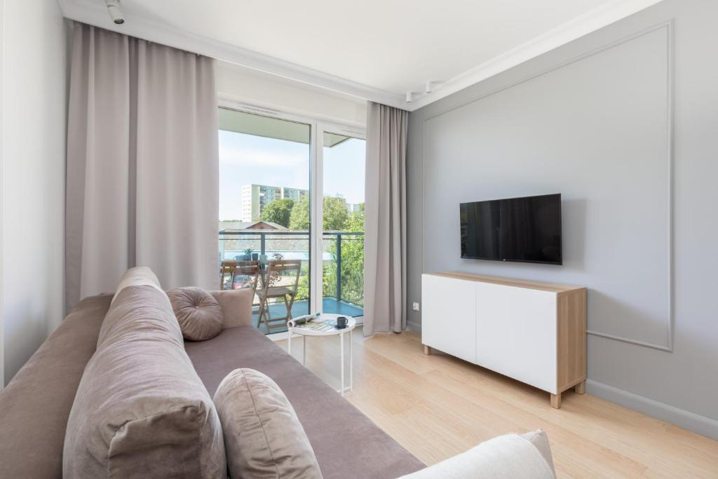 Televízia a/alebo spoločenská miestnosť v ubytovaní Green Square Apartments Świnoujście by Noclegi Renters