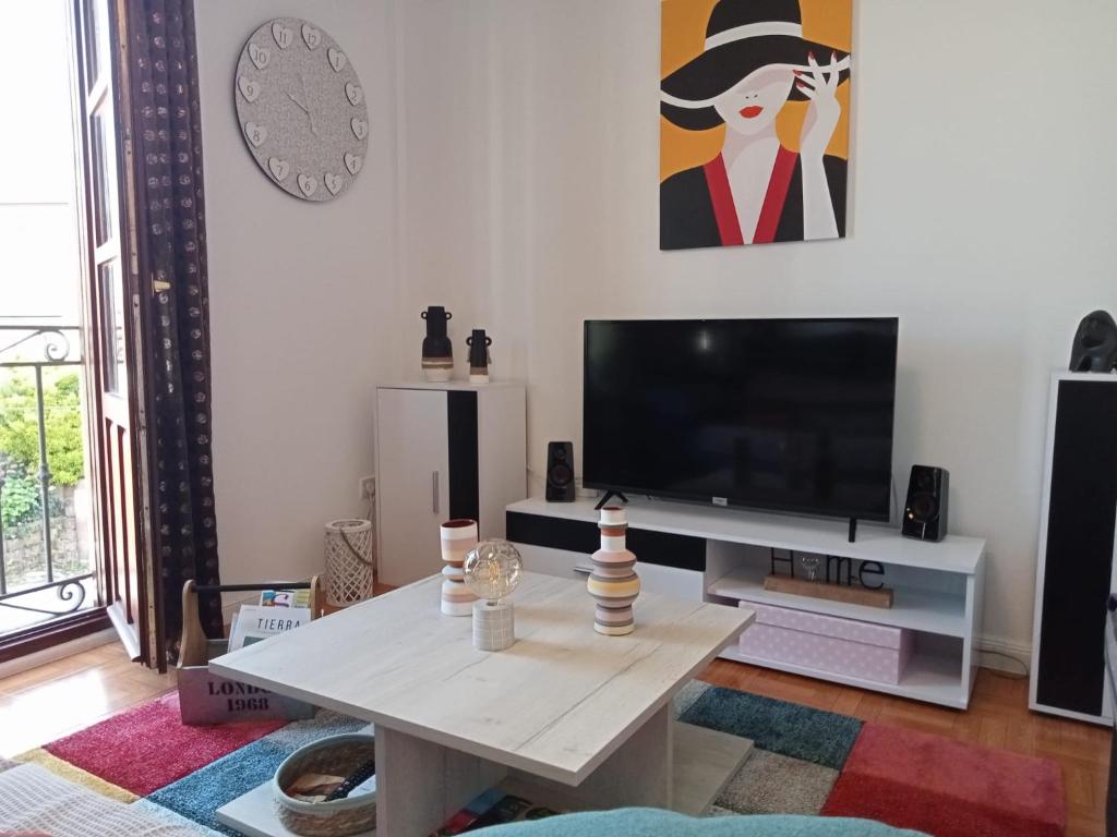 sala de estar con TV y mesa de centro en Coquetty Housing In Santander Bay en El Astillero