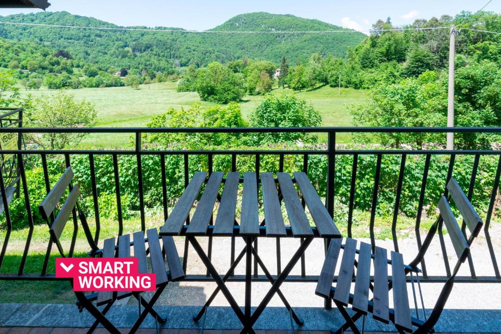 een picknicktafel en stoelen op een balkon met uitzicht bij Costa Prada Country House by Wonderful Italy in Bellagio