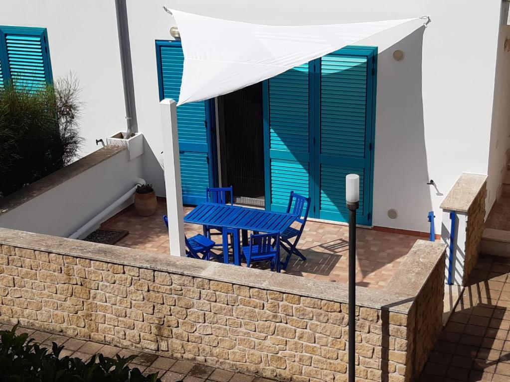 un patio con sillas azules y una mesa azul en Appartamento MaRi con piscina, en Torre Lapillo