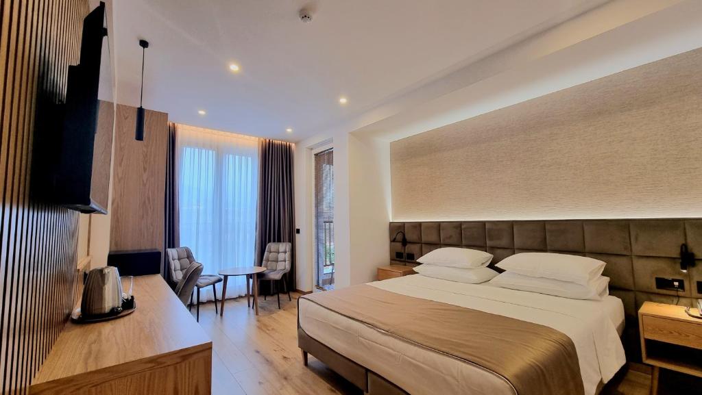 Cette chambre comprend un grand lit et un bureau. dans l'établissement SIBB Hotel, à Tirana