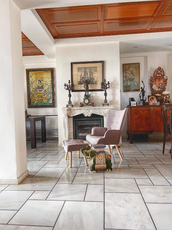 salon z kominkiem, stołem i krzesłami w obiekcie Home House Rethymno w Retimnie