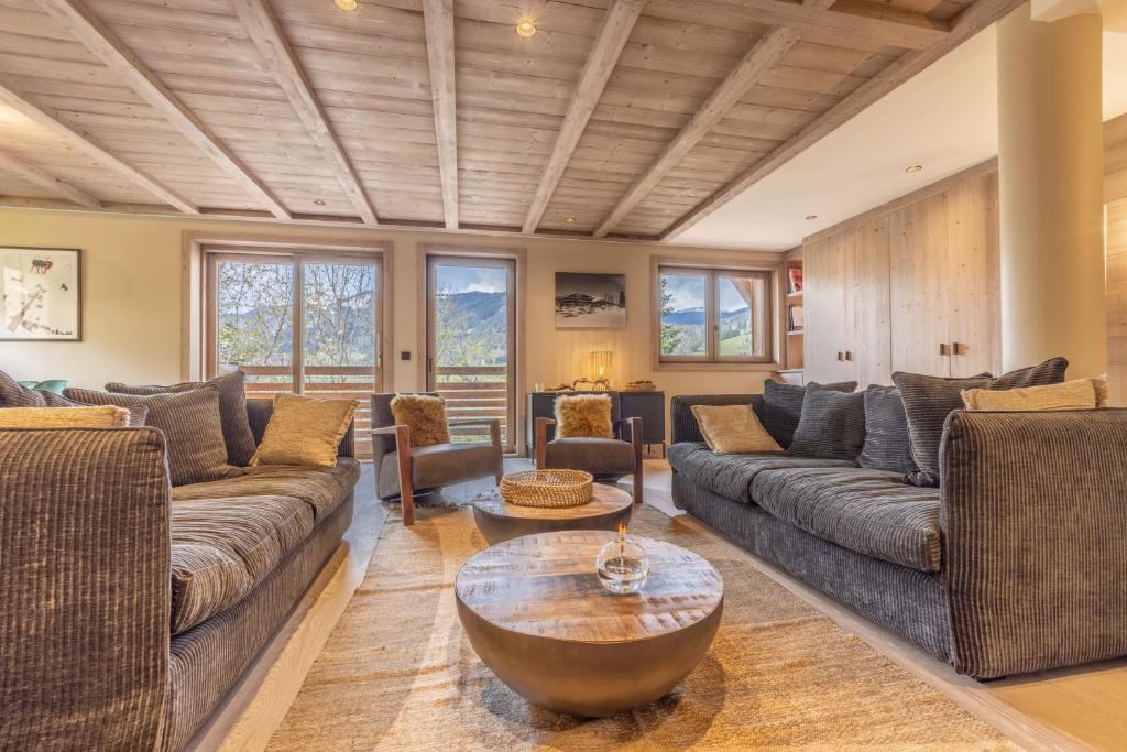 a living room with couches and a table at Bleu Eskape - Appartement in Megève