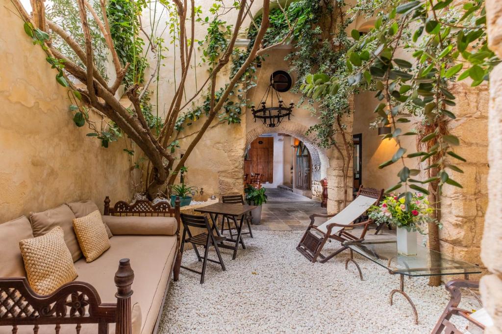 an outdoor patio with chairs and a table and a tree at Hotel Boutique V in Vejer de la Frontera