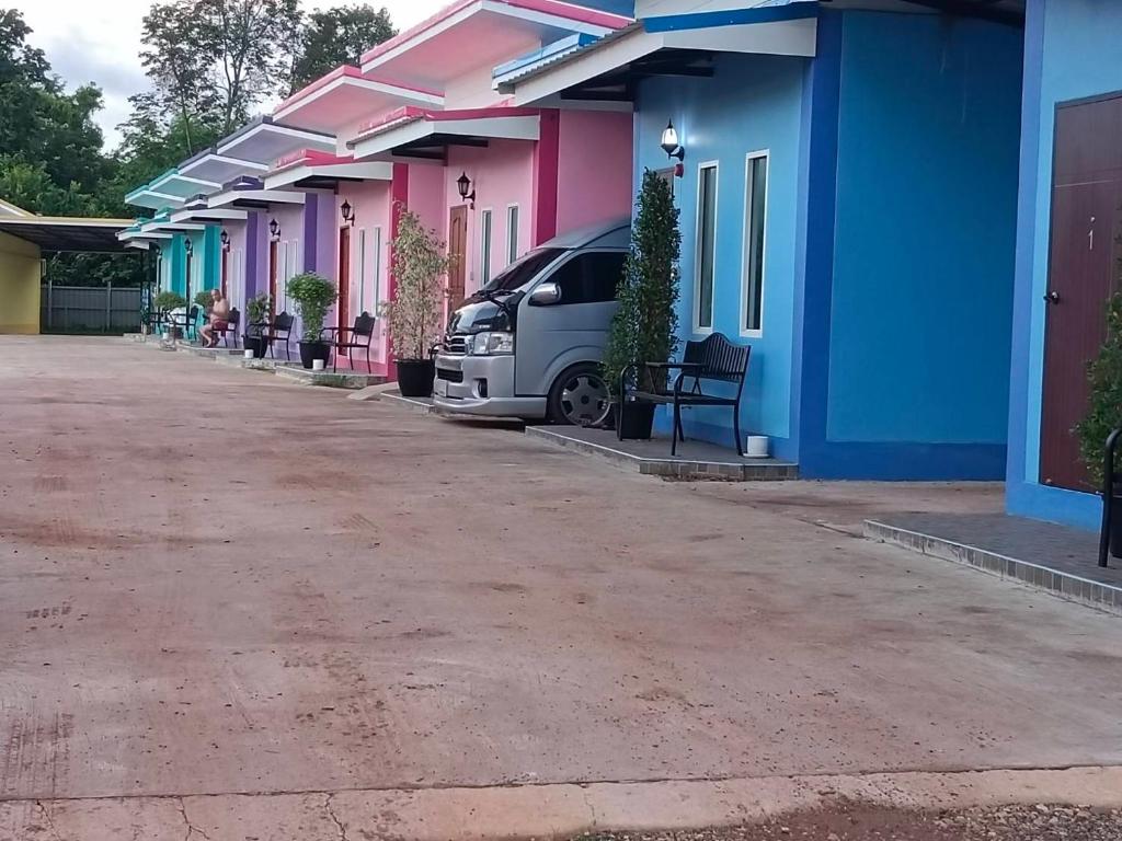 a row of colorful houses with a van parked outside at JUNPEN RESORT in Ban Hai Yong