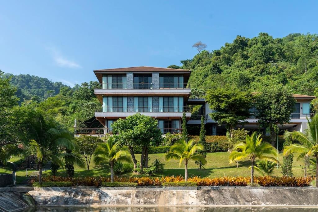 una casa en una colina con palmeras delante en President R1-3 The Height Khaoyai 3BR byน้องมังคุด en Ban Huai Sok Noi