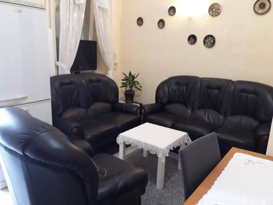un soggiorno con mobili in pelle nera e un tavolo di Apartman Slavonija 2 a Osijek