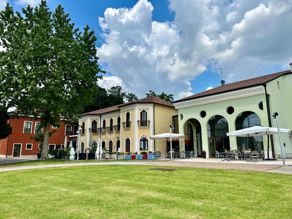 a group of buildings with a lawn in front at Hotel Alle Acque in Lonigo