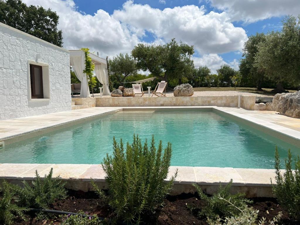 duży basen w ogrodzie z domem w obiekcie Trullo Perla Greta - Luxury Country Villa & private heated pool w Alberobello