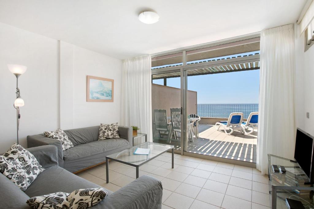 een woonkamer met een bank en uitzicht op de oceaan bij Casa Médano 19 By Médano Rentals in El Médano
