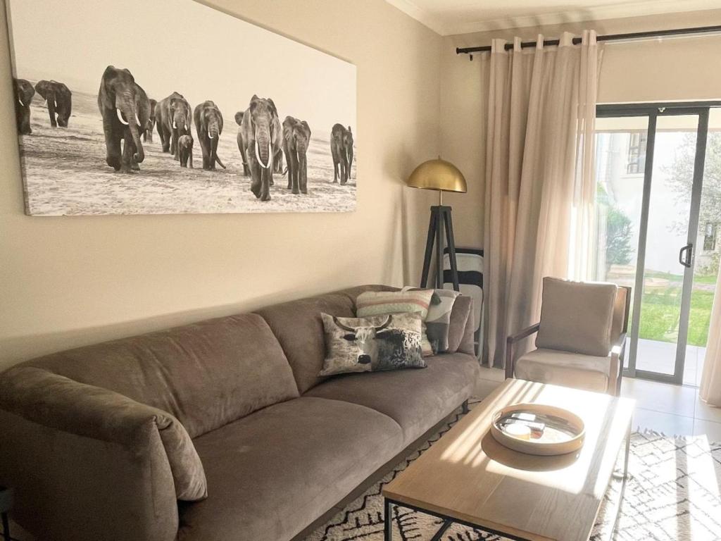 a living room with a couch and a herd of elephants at Executive Modern Apartment in Fourways