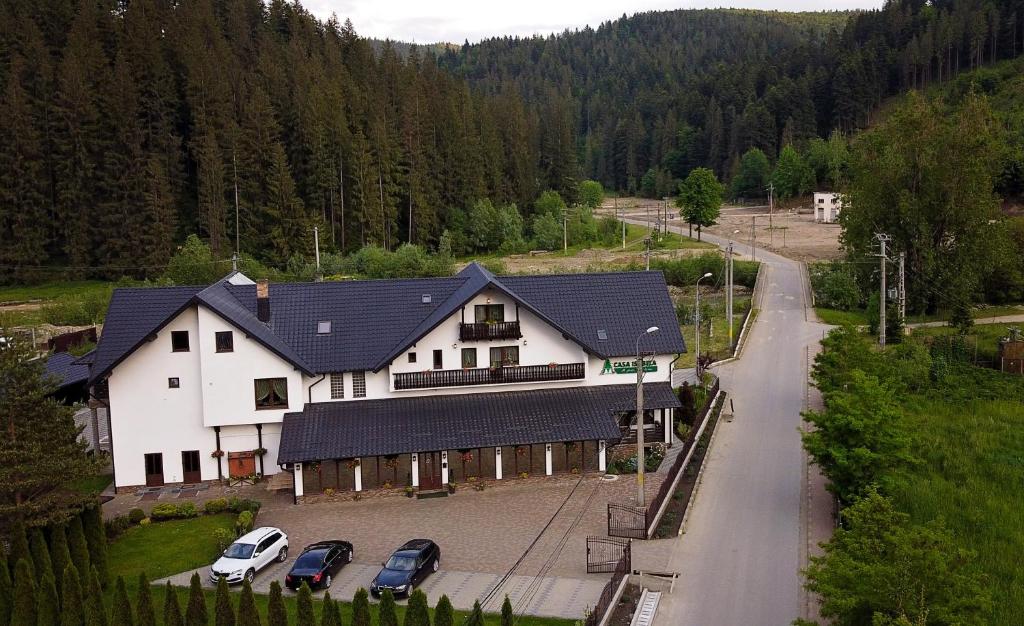 ein großes weißes Haus mit Autos in einer Einfahrt in der Unterkunft Casa Isabela in Putna