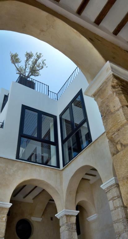 an archway with a potted plant on top of a house at Hotel Boutique V in Vejer de la Frontera