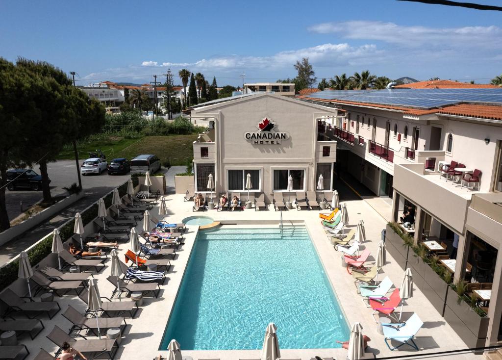 una vista aérea de un hotel con piscina y sillas en Canadian Hotel, en Laganas