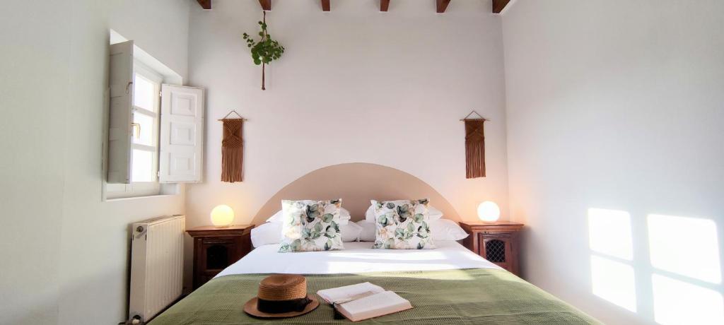 Las RozasにあるCasa Florentaのベッドルーム(ベッド、帽子付)