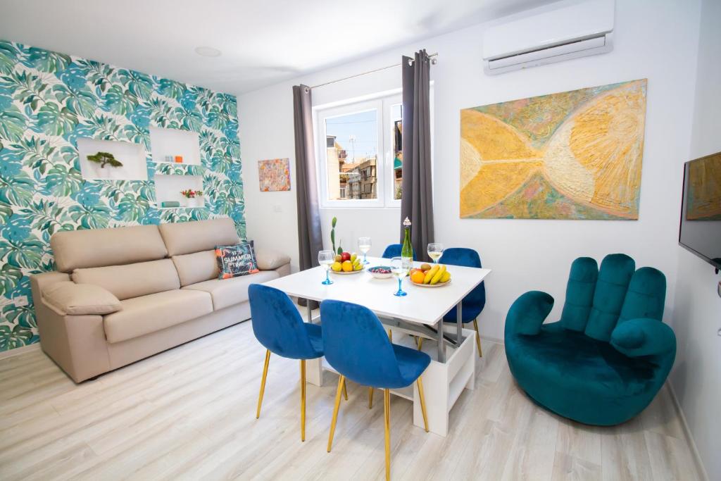 salon ze stołem i niebieskimi krzesłami w obiekcie Art Apartments Alicante w Alicante