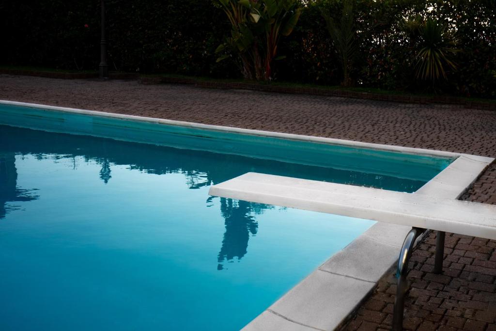 a white bench sitting next to a swimming pool at Blu Apartment in Historical Hunbury in Bordighera