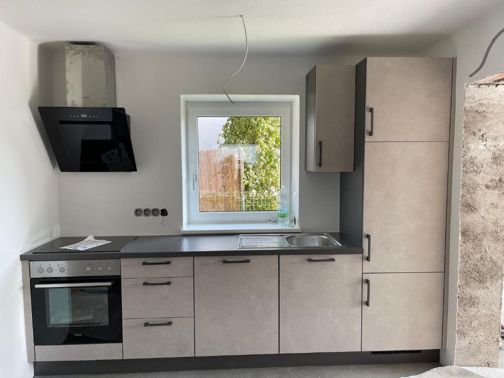 a kitchen with a sink and a window at Kleine Ferienwohnung Nähe Amstetten in Spiegelsberg