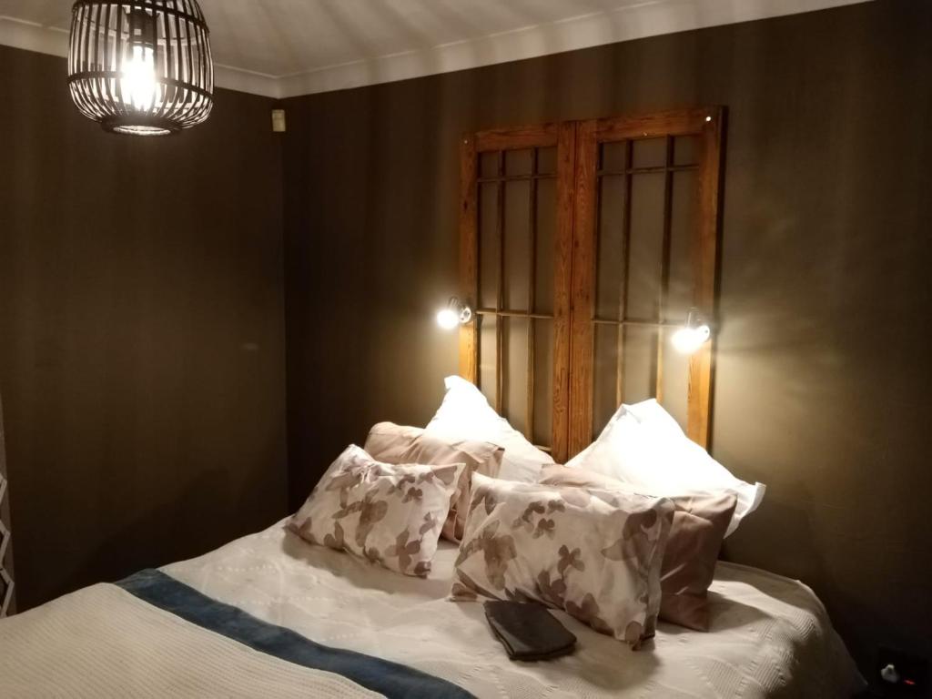 a bedroom with a bed with pillows and a chandelier at Pecan Tree Parys in Parys