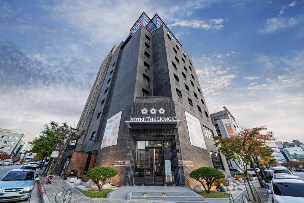 a tall building with a sign on the front of it at The Hong C Hotel in Gangneung