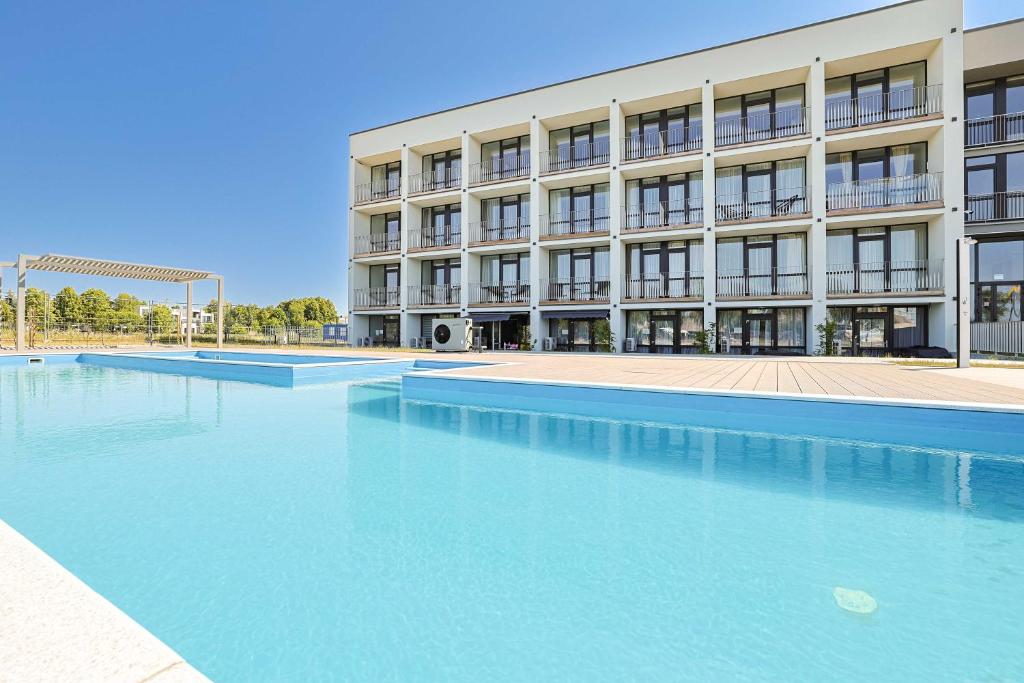 a large swimming pool in front of a building at Aqua Apartment Šventovė, By Cohost in Palanga