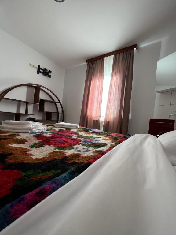 - une chambre avec un lit et une couverture colorée dans l'établissement Les gîtes du Valjoly 1, à Touvent