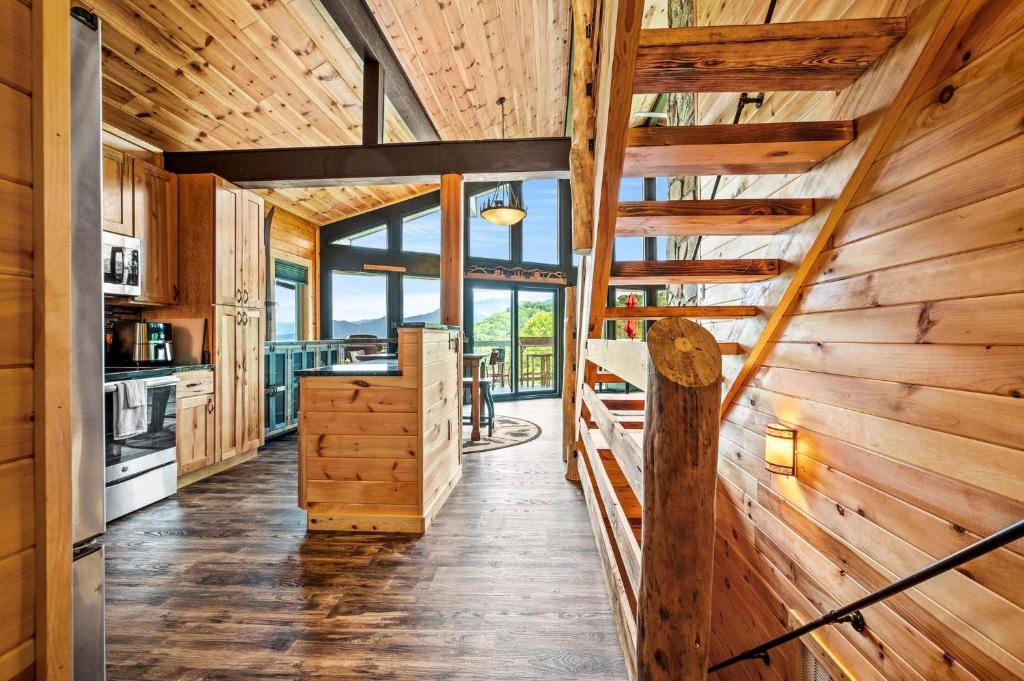 a log cabin kitchen with wooden walls and a staircase at Sunrise View Chalet in Gatlinburg
