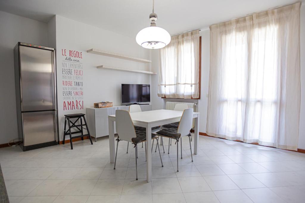uma sala de jantar com uma mesa branca e cadeiras em La terrazza di Giulietta em San Giovanni Lupatoto